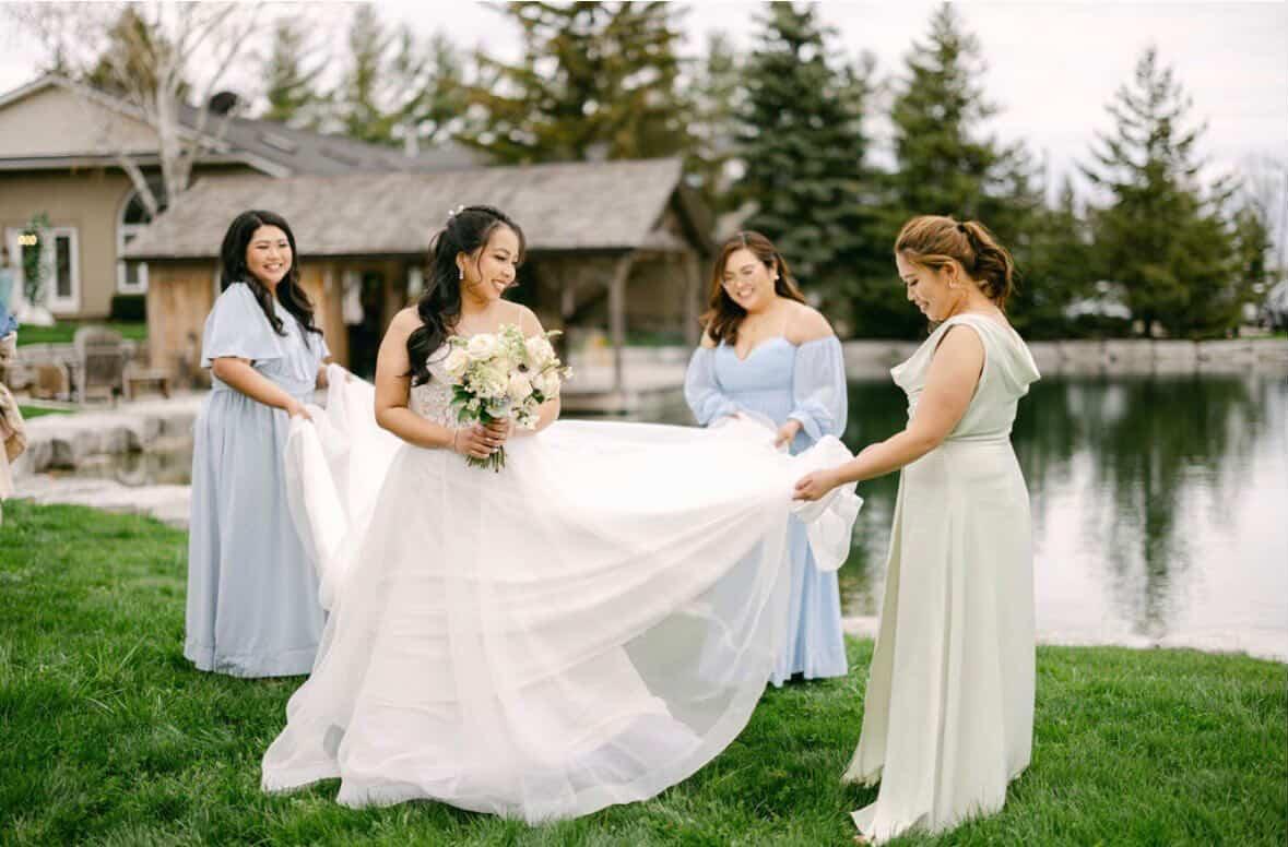 Bride and bridesmaids in blue dresses by the pond