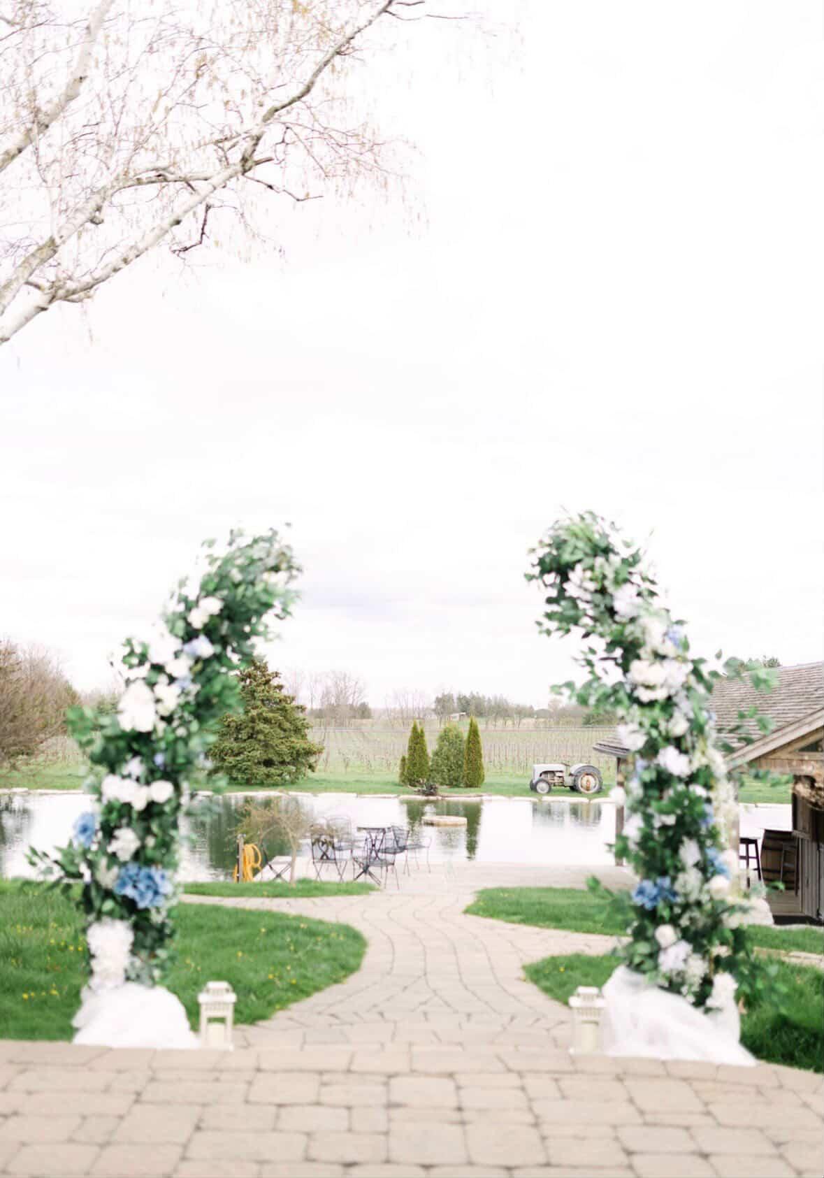 Floral ceremony arch overlooking the pond and vineyard