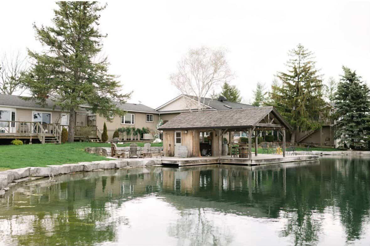 The gazebo and boathouse reflected in a still pond