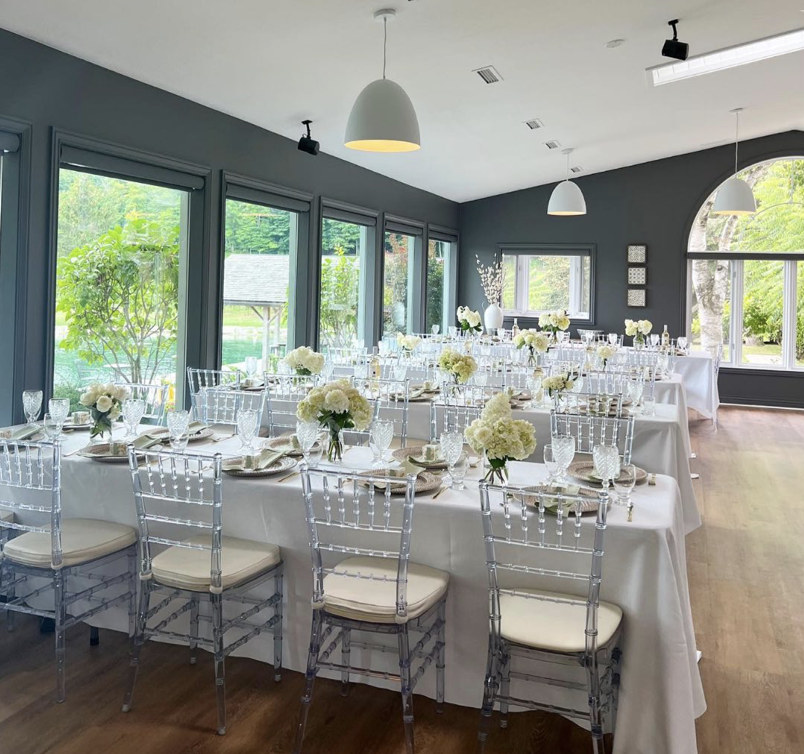 Wedding reception tables styled with white hydrangeas and gold-rimmed glassware at a Niagara vineyard wedding