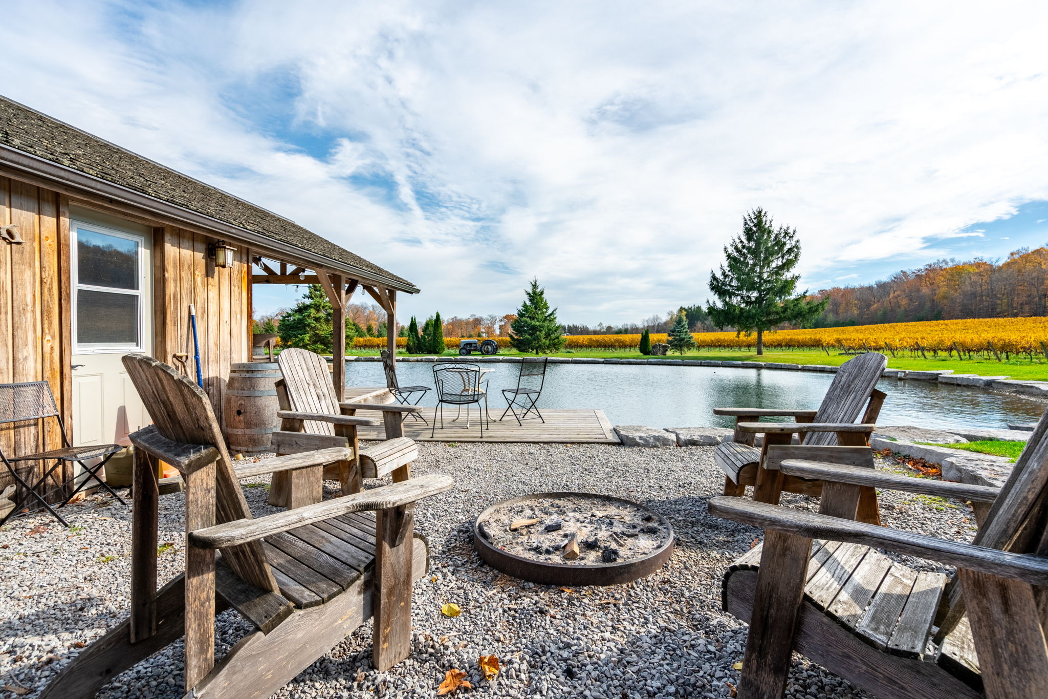 Fire pit and Adirondack chairs with pond and vineyard views
